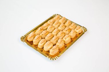 beyaz zemin üzerinde altın bir tepsi kekleri