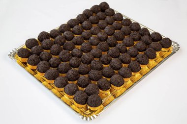 beyaz zemin üzerinde altın bir tepsi içinde trüf çikolata cupcakes