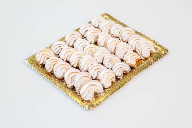 Beyaz arka plan ile altın bir tepsi üzerinde şekerli kurabiye