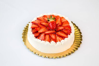 beyaz arka planda bir altın tepsi üzerinde güzel çilek ve krem kek