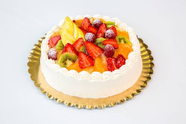 beyaz zemin üzerine altın tepside güzel meyveli kek