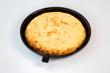 potato omelet on a black tray prepared to takeaway on white background