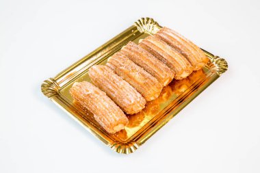 sweet fritter stuffed churro on a gold tray with white background