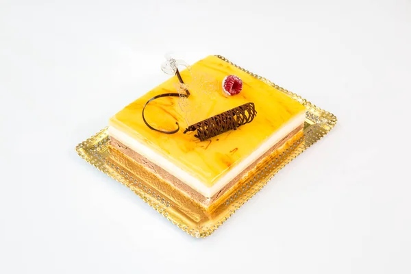 beautiful yellow cake on a gold tray on white background