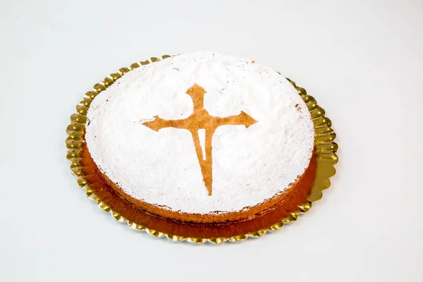 beautiful santiago cake on a gold tray on white background