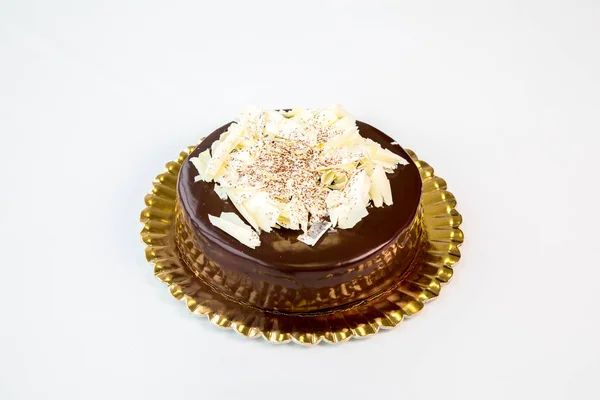 beautiful chocolate cake on a gold tray on white background