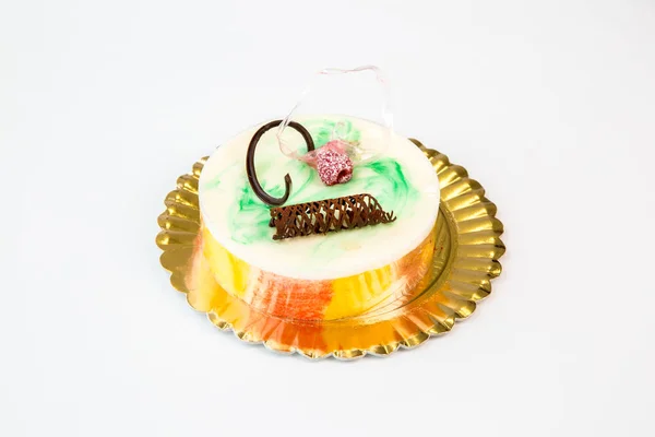 beautiful colorful cake on a gold tray on white background
