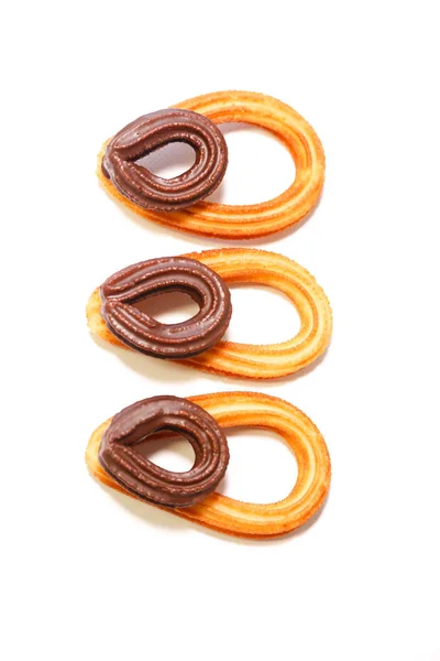 Beignets espagnols avec petites beignets au chocolat sur le dessus sur fond blanc — Photo