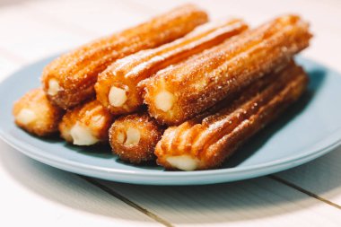 İspanyol şeker börek mavi tabak ahşap bir masa üzerinde yılları arasında görev yapmıştır