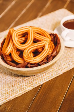 İspanyol börek bir fincan sıcak çikolata ile ahşap bir masa yılları arasında görev yapmıştır