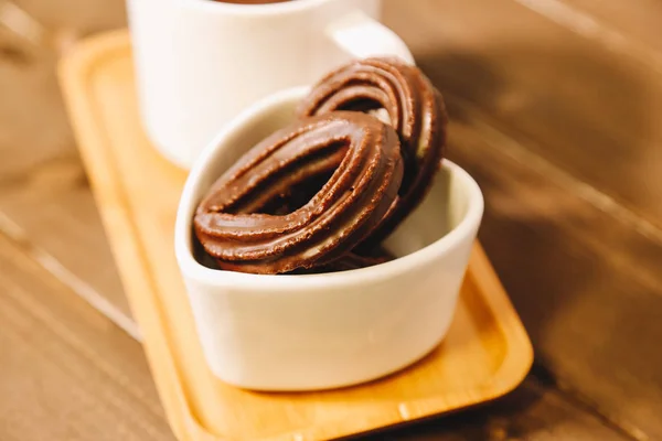 Pequeños buñuelos de chocolate español servidos en una mesa de madera — Foto de Stock