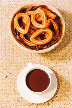 İspanyol börek bir fincan sıcak çikolata ile ahşap bir masa yılları arasında görev yapmıştır