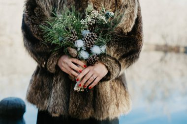 bir kürk ceket bir kış gelin buketi tutan bir gelin