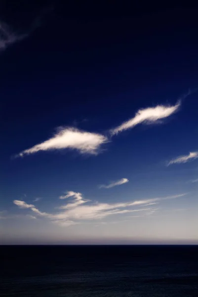 Les nuages blancs sur la mer sombre — Photo