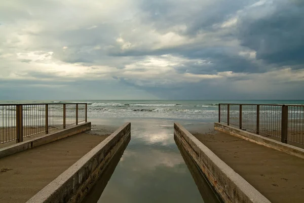 Um pequeno rio derrama suas águas no mar Adriático — Fotografia de Stock