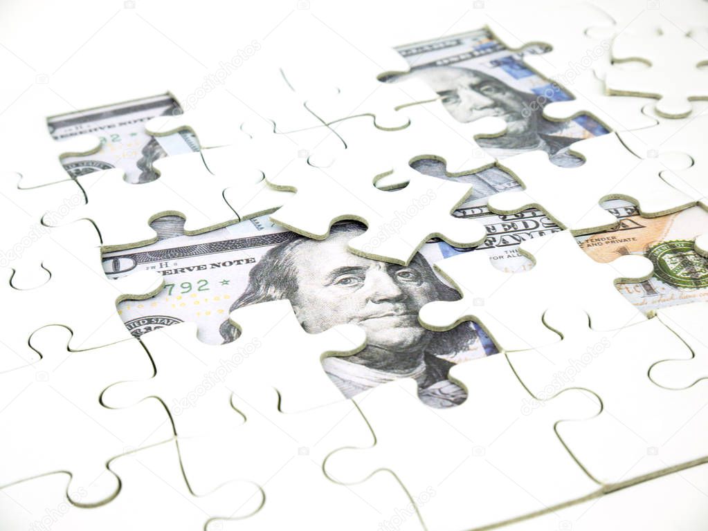 Missing jigsaw puzzle pieces on 100 Dollar money background, Key for Business solution success concept.