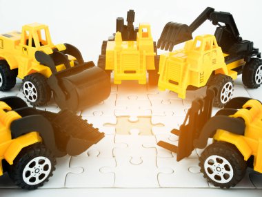 Ekip çalışması ve Mühendislik İnşaat kavramı ile oyuncak buldozer, basınç road, vinç, Forklift ve jigsaw puzzle.