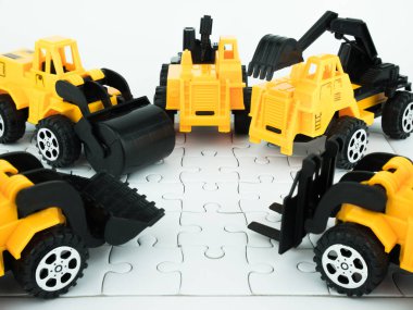 Ekip çalışması ve Mühendislik İnşaat kavramı ile oyuncak buldozer, basınç road, vinç, Forklift ve jigsaw puzzle.