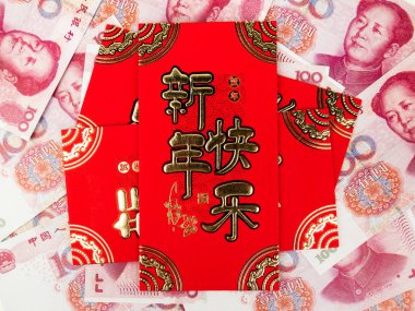 Çin para 100 yuan banknotlar üzerinde Çin kırmızı zarf arka plan olarak kazık. Mutlu çene yeni yıl anlamına gelen zarf üzerinde Çince metin.