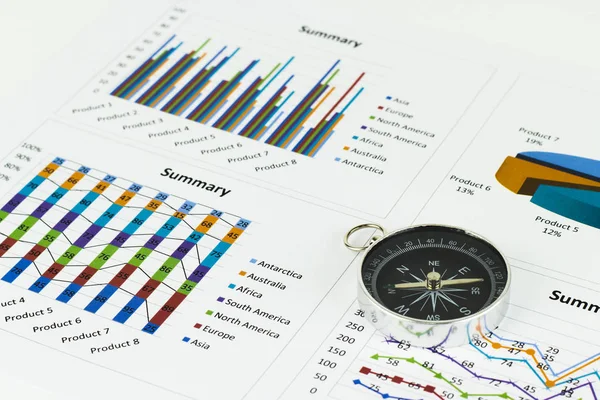 Bussiness graphs and finances with a compass lying nearby.