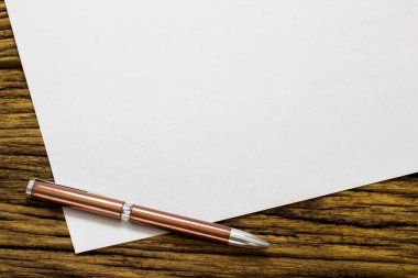 Kağıt ve kalem eski ahşap arka plan üzerinde boş sayfa.