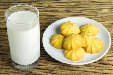 Ahşap zemin üzerine soğuk süt ile tabak kurabiye.