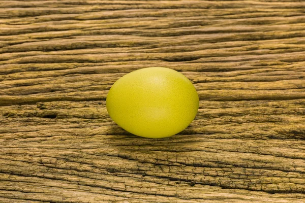 Yellow ester egg on a wooden bacground.