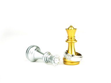 Beyaz arka plan üzerinde düğün kavramı izole altın ve gümüş standart satranç ile elmas yüzük.