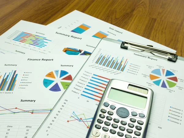 Business report chart and Financial graph analysis with calculator on table.