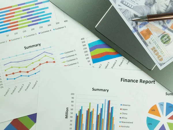 Business report chart and Financial graph analysis with dollar money and pen on the table.