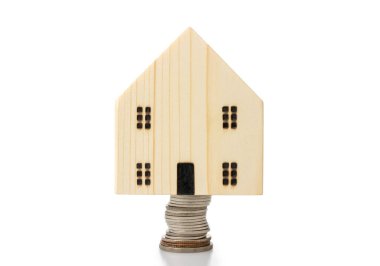 Ev kredileri, maddi planlama kavramı ile tasarruf edilen madeni paralar, beyaz arka planda izole edilmiş..