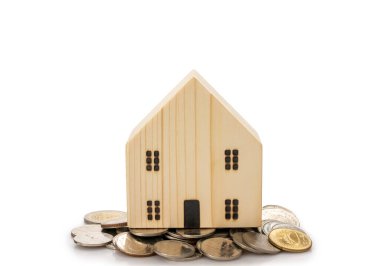 Ev kredileri, maddi planlama kavramı ile tasarruf edilen madeni paralar, beyaz arka planda izole edilmiş..