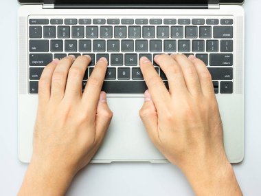 Modern beyaz ofis masasında erkek elleri dizüstü bilgisayarda çalışıyor..