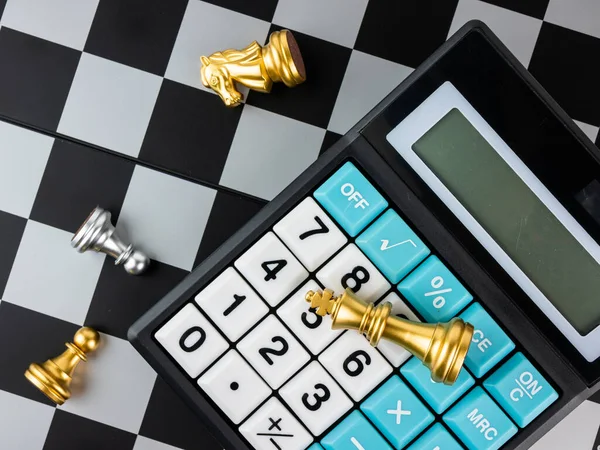 Finansal oyunlar konsepti, hesap makineli satranç oyunu, seçici odaklanma.