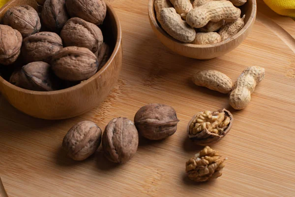 Walnuts kernels on dark desk with color background, Whole walnut in wood vintage bowl, Nuts in bamboo wooden bowl, walnuts in wood