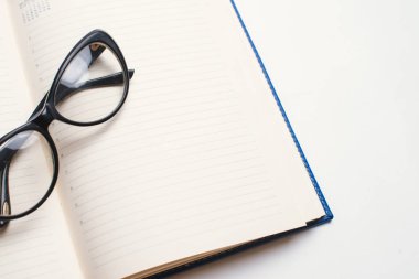 Defter ile gözlük ve kalem, kitap ile gözlük, Gözlük, gözlük ve kalem, çalışma çay, kitapla mavi defter not defterine yazmak