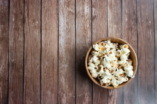 Salzpopcorn auf dem Holztisch. Popcorn in einer Holzschüssel. — Stockfoto