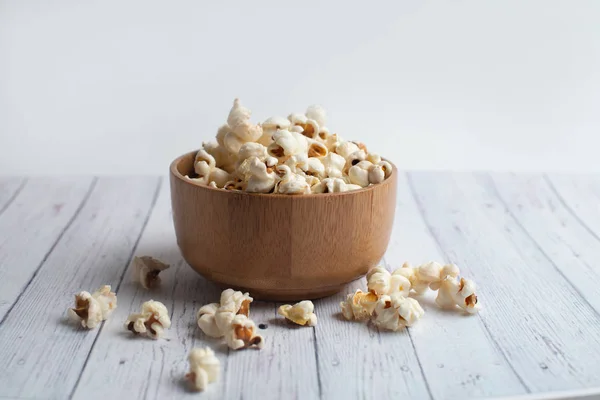 Salzpopcorn auf dem Holztisch. Popcorn in einer Holzschüssel. — Stockfoto