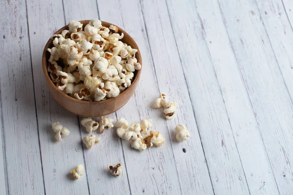 Salzpopcorn auf dem Holztisch. Popcorn in einer Holzschüssel. — Stockfoto