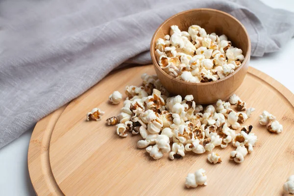 Salzpopcorn auf dem Holztisch. Popcorn in einer Holzschüssel. — Stockfoto