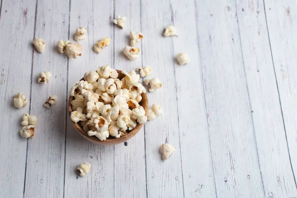 Salzpopcorn auf dem Holztisch. Popcorn in einer Holzschüssel. — Stockfoto