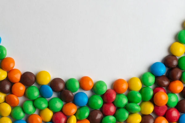 Színes keret, a fehér háttér színes cukorkák — Stock Fotó