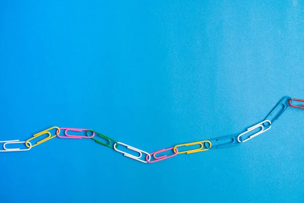 Mavi arka planda renkli ataçlar. Okula geri dön. Çeşitli