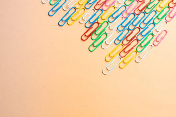 Turuncu arka planda renkli ataçlar. Okula geri dön. Vario