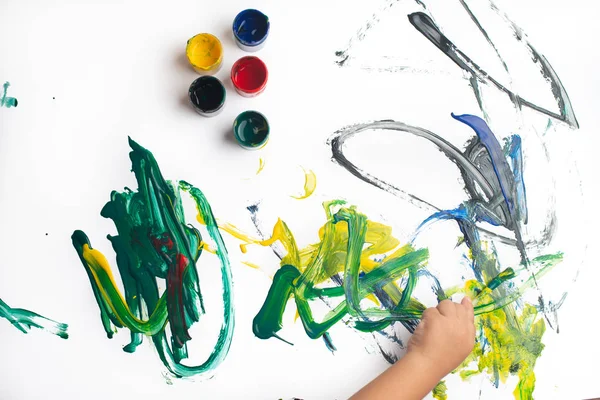 Mãos de um menino pintando com aquarelas em papel branco s — Fotografia de Stock