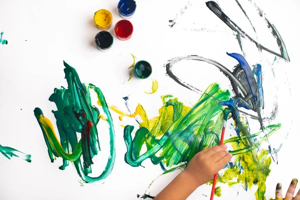 Mãos de um menino pintando com aquarelas em papel branco s — Fotografia de Stock