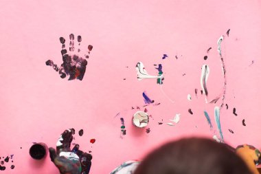 Pembe kağıt sh suluboya ile boyama küçük bir çocuğun elleri