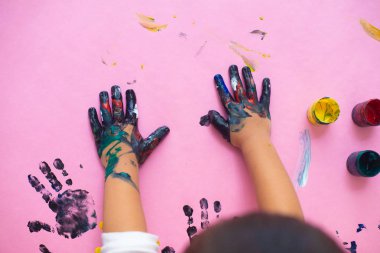 Pembe kağıt sh suluboya ile boyama küçük bir çocuğun elleri