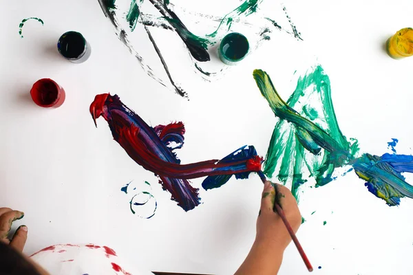 Mãos de um menino pintando com aquarelas em papel branco s — Fotografia de Stock