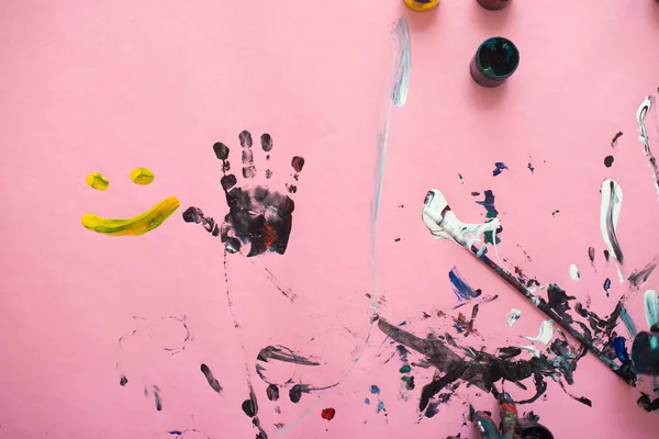 Mãos de um menino pintando com aquarelas em papel rosa sh — Fotografia de Stock